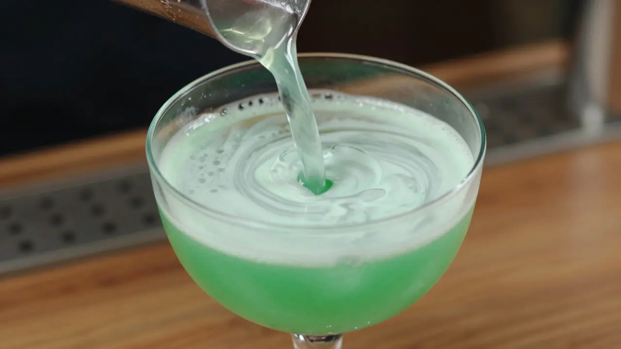 Makro záběr přípravby absintu s efektem louche při přilévání vody